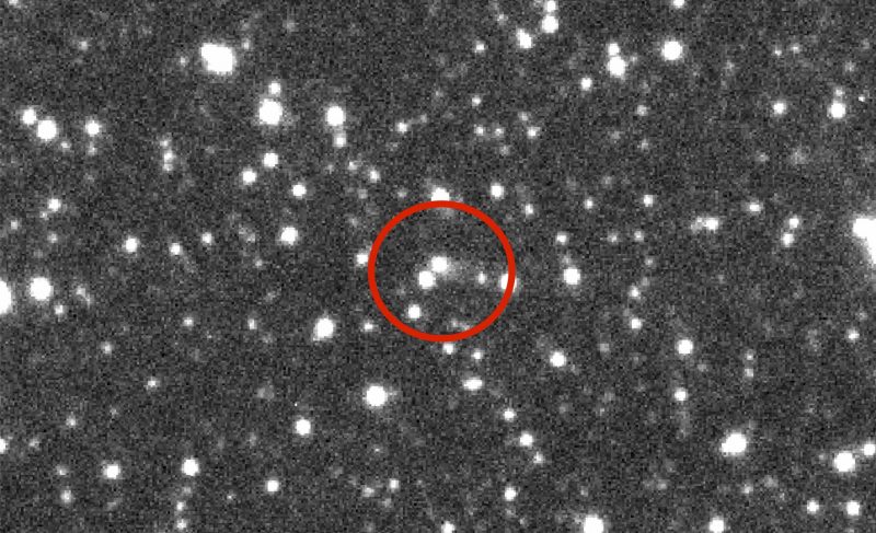 Many fuzzy white dots with red ring in center of image, on black background.