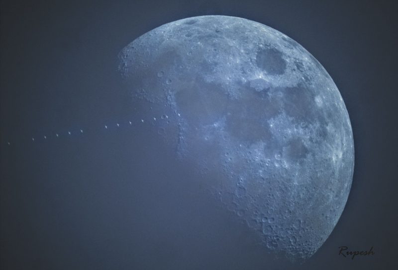 A blue-colored moon, with ISS tracking in front of it.
