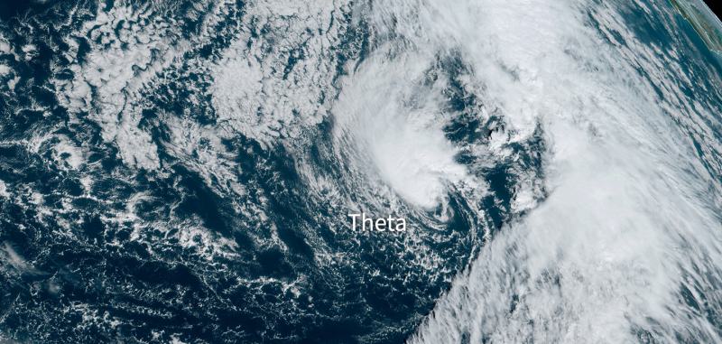 Orbital view of dark blue sea nearly covered with white clouds in a spiral.