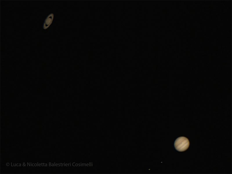Two planets, faint Saturn with rings and banded Jupiter, against a black background.