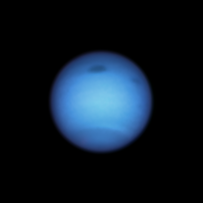 Large bluish planet with two dark spots and bands in the atmosphere.