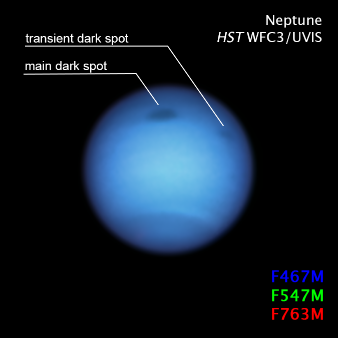 Large bluish planet with two labeled dark spots and text annotations, on black background.