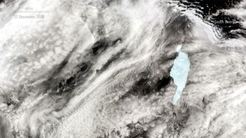 Satellite image cloud-covered sea, island visible, and large white area with one small piece separate.