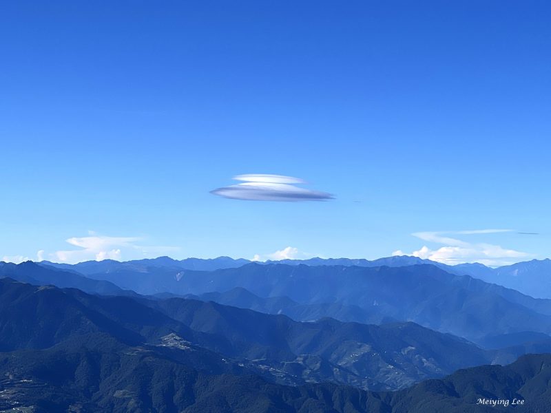 White stacked oval clouds over mountains.