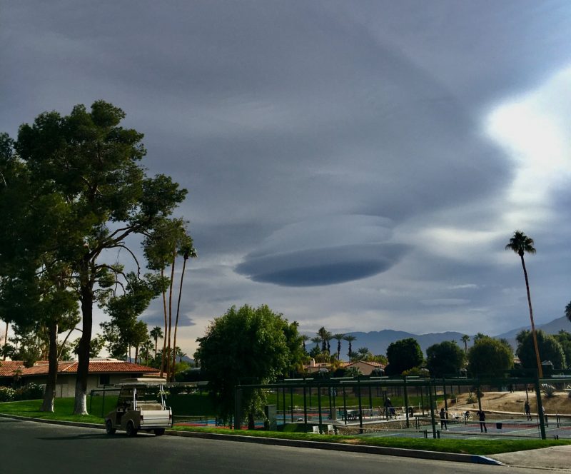 California town with saucer-shaped lenticular clouds above.