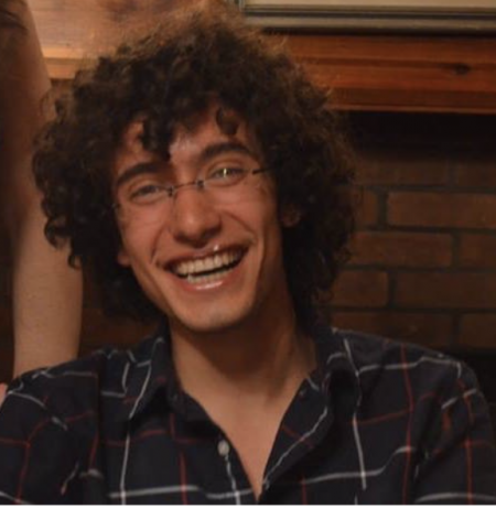 Laughing young man with a lot of curly hair.