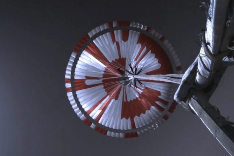 Parachute with white and orange radial patterns on the inside.