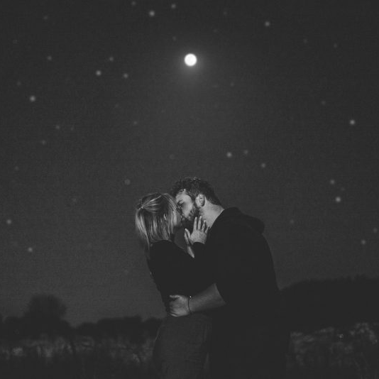 The science of kissing: Couple kissing in the dark, under the moon.