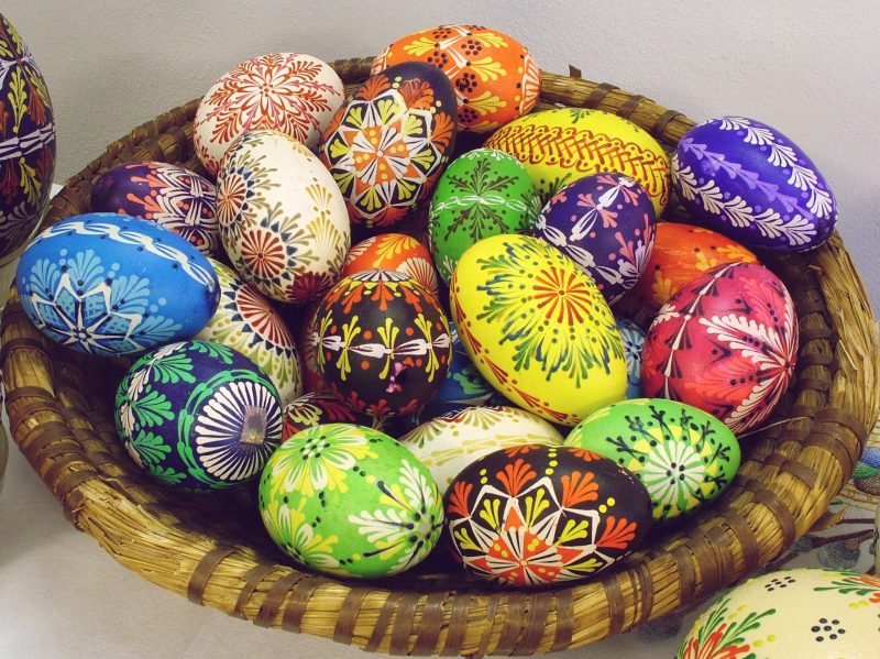 Basket of eggs with brightly colored, intricate designs painted on them.