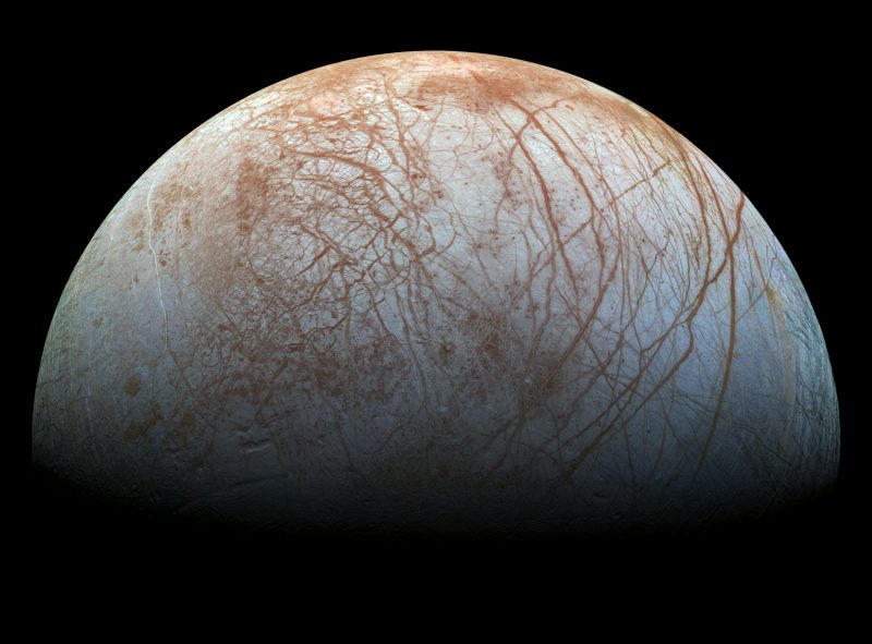 Red cracks on Europa's smooth, icy, grey-white, surface.