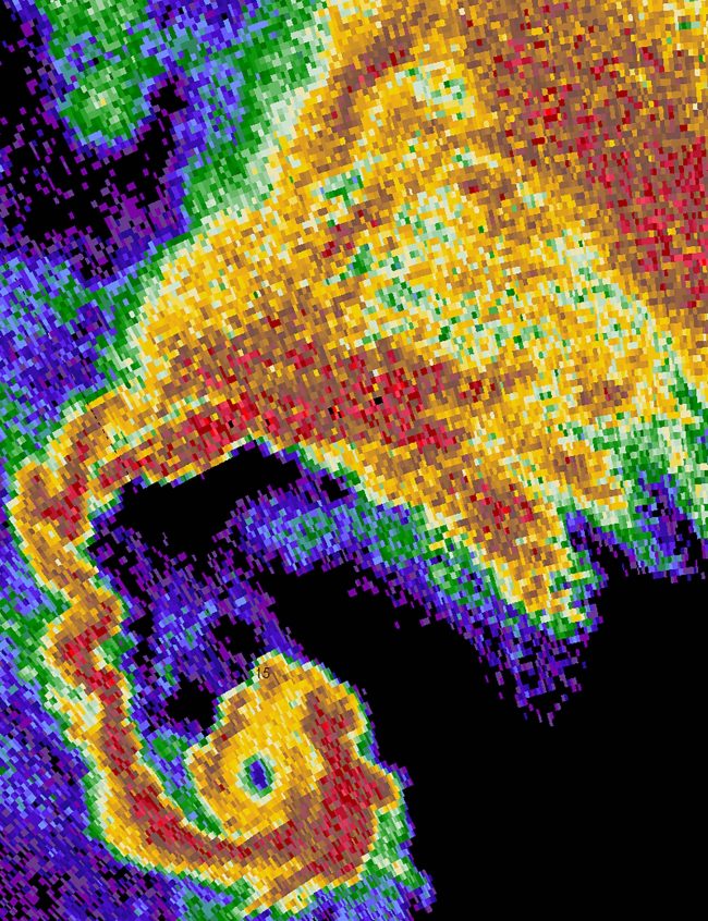 Multicolor radar image of hook curving left to right into tight spiral.