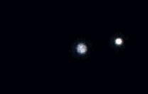 Two tiny Jovian moons, one passing nearly exactly in front of the other.