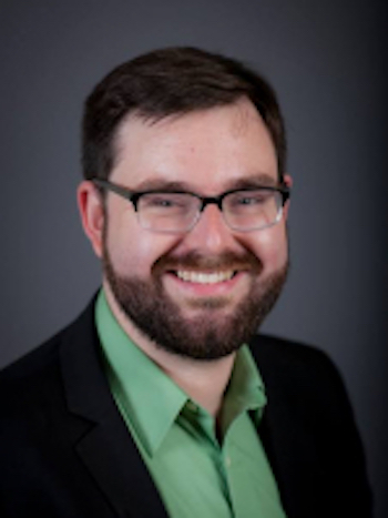 Smiling man with eyeglasses and beard and green shirt.