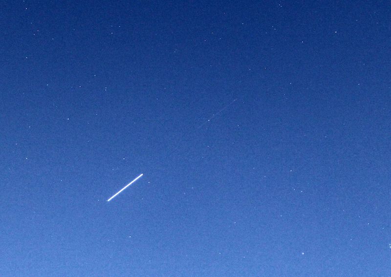 Blue sky with stars, and 2 white streaks on the diagonal after each other, one bright and one very faint. 