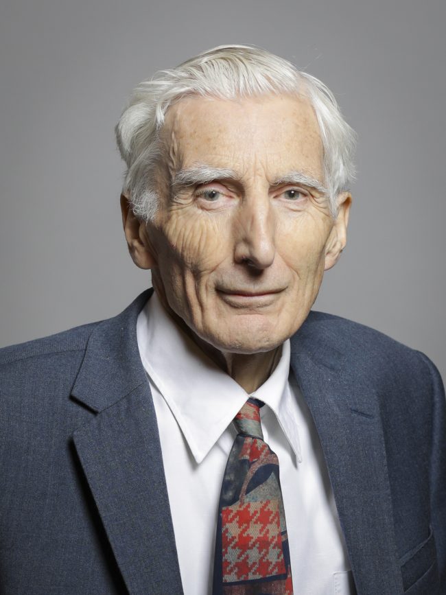 Elderly man with white hair in suit and tie.