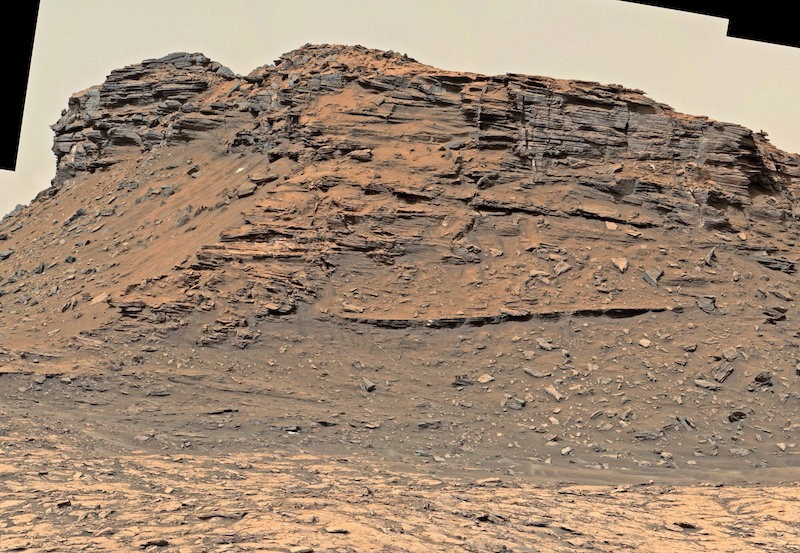 Bare rocky outcrop with horizontal layers.