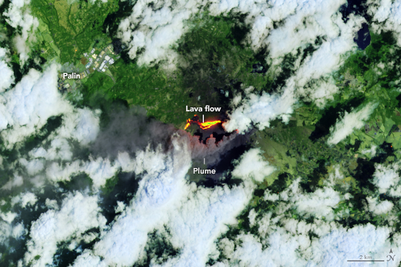 Vista orbital de nubes blancas sobre un bosque verde con dos manchas de color amarillo anaranjado brillante etiquetadas como lava.