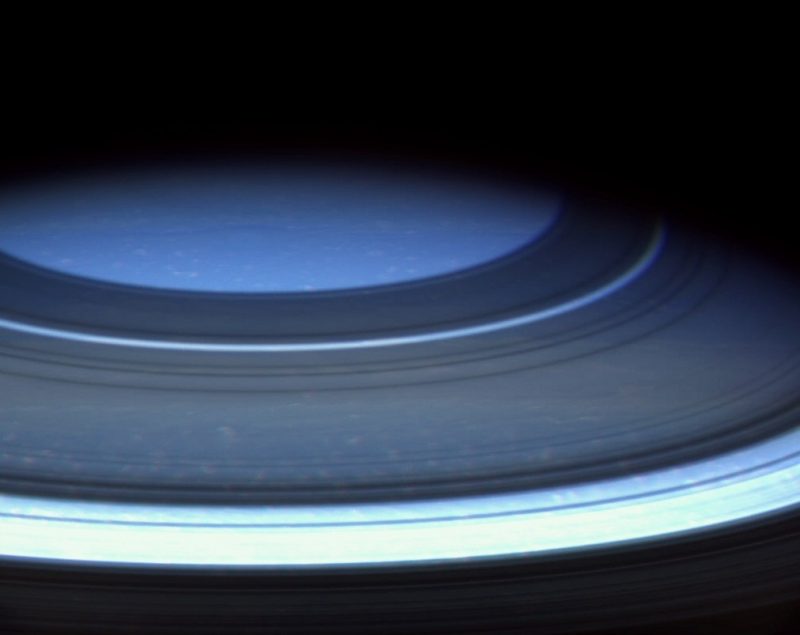 Closeup of many parallel bluish rings and piece of blue orb.