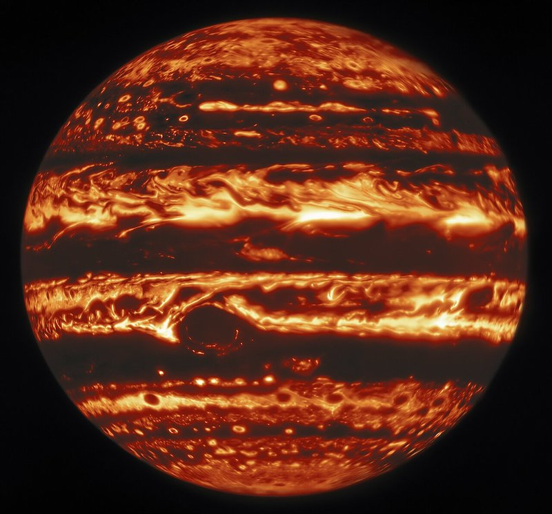 Jupiter with glowing red and yellow bands of clouds, on black background.