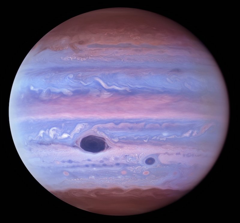Jupiter with clouds in bluish pastel colors and large, deep blue spot.