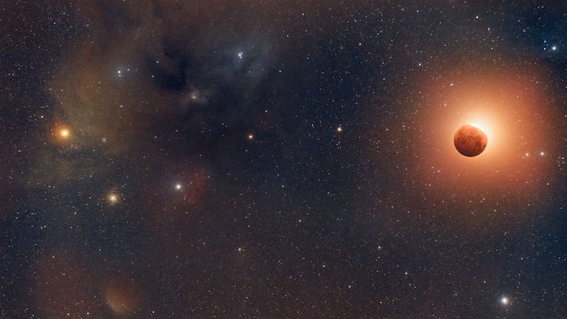 The orange eclipsed moon is pictured to the right while a collection of colorful stars glow on the left.