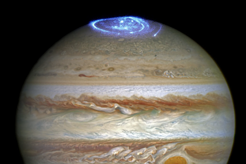 Jupiter X-ray auroras: A brown and orange marbled sphere with a bright blue glowing swirl at the top.