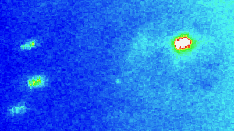 A washed out blue field of view with faint halo surrounding yellow-white object which is Comet C/2021 O3.