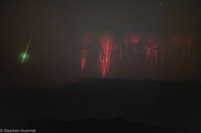 A bright green meteor streaks along on one side of the photo. On the other side is a red, jellyfish-like lightning sprite.