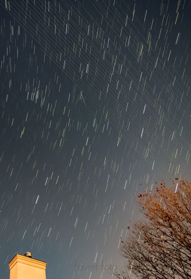 Satellites versus stars: Many short white lines in a dark sky and close-together long parallel lines cutting across.