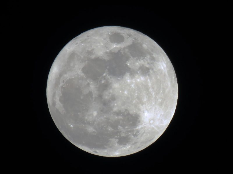 Full moon in white and gray with black background.