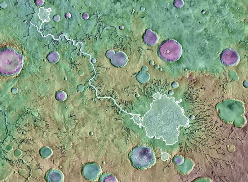 Orbital view of craters on Mars, some containing overflowing lakes.