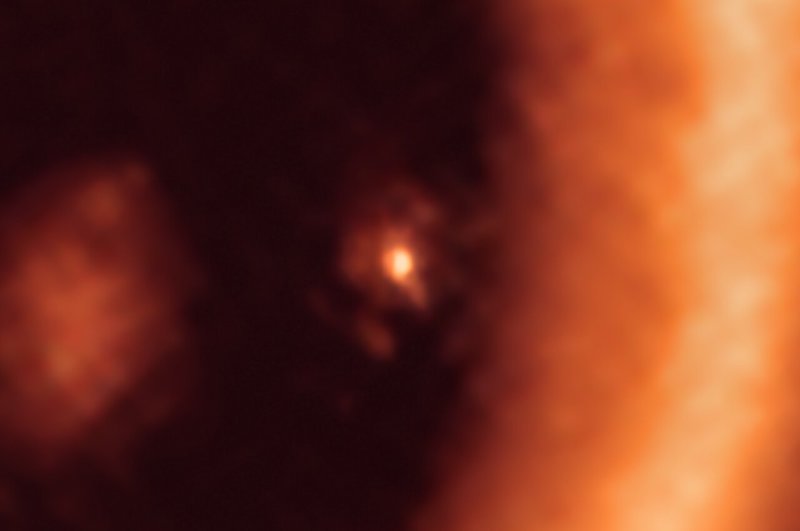 Bright dot surrounded by dusty orange moon-forming disk.