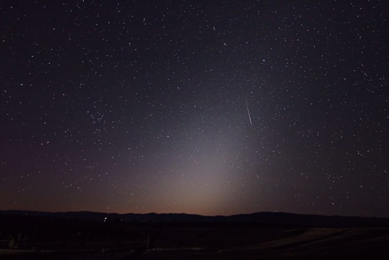 How high up are meteors: Slanted cone of fuzzy, dim light in night sky with short, thin streak of light near top.