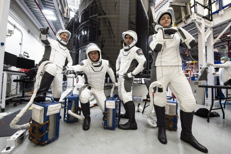 Four astronauts clowning around, in spacesuits.