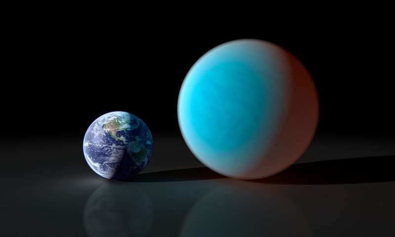 Earth next to a larger planet with plain atmosphere, on black background.