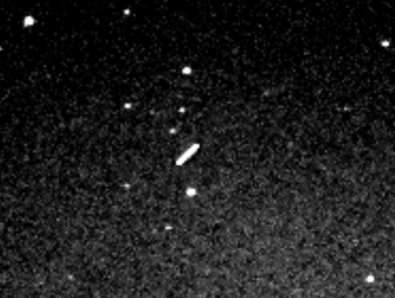 White streak of light at center among white dots denotes asteroid in dark field.