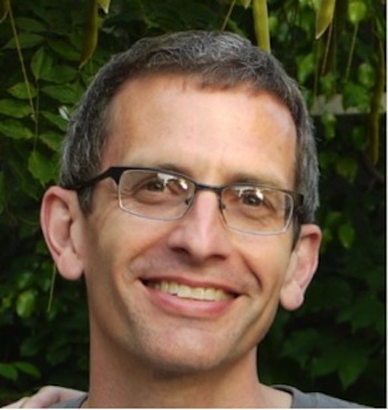 Short-haird smiling man with eyeglasses.