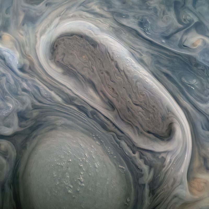 Juno image: Two giant whorls in shades of beige and gray with bubbling tops.
