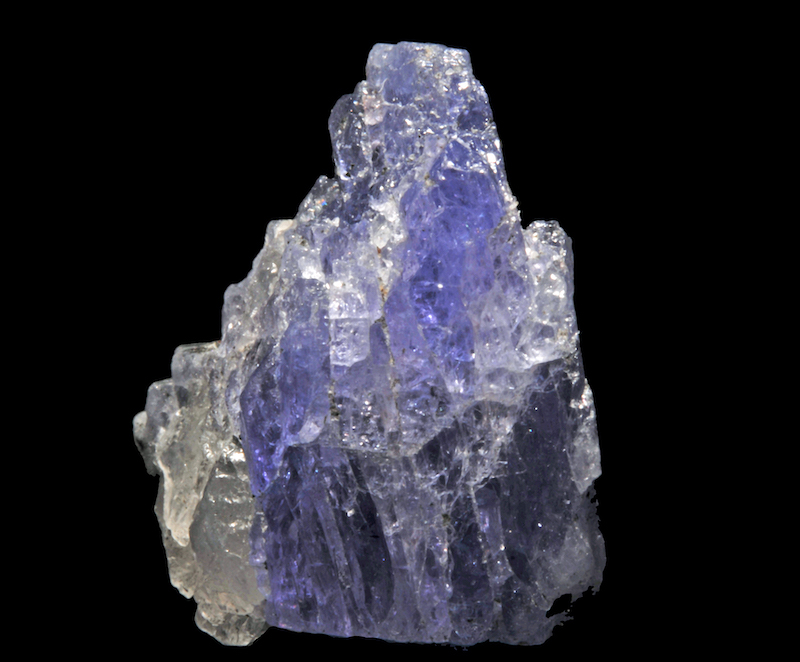 A rugged transparent light blue-violet rock with some transparent white regions.