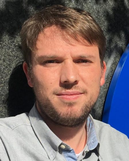 Close up on man's face with light beard and sandy hair.