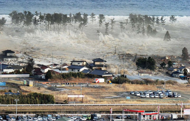 Tsunami warnings: A giant wave heading toward a residential area.