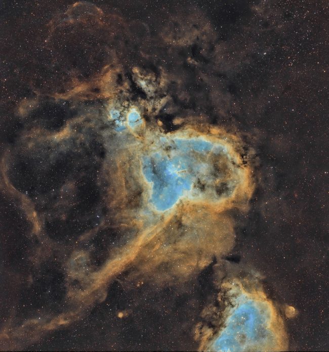 Blue nebula outlined in orange in upside down heart shape.