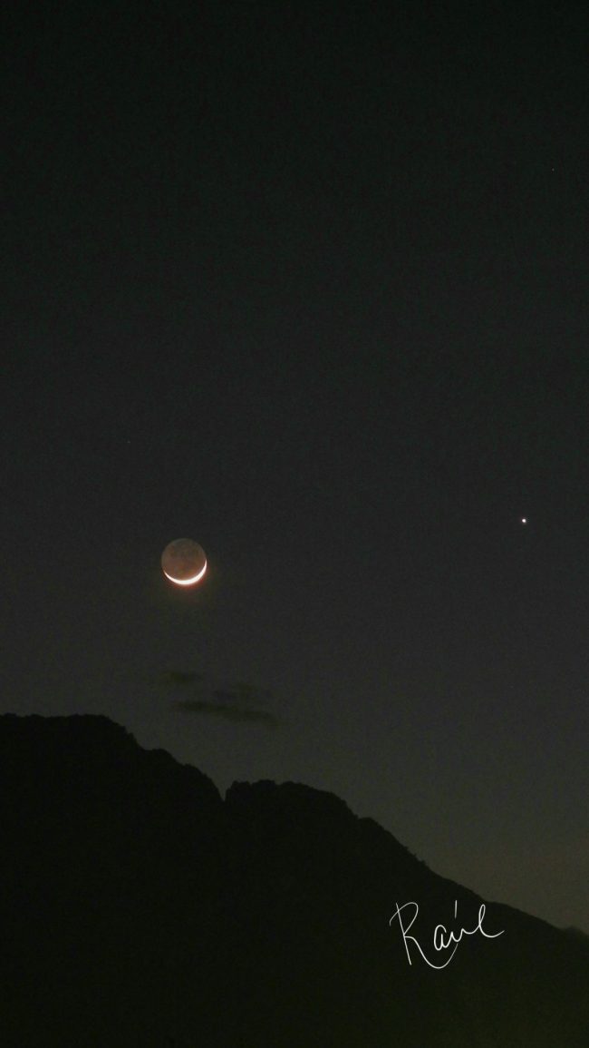 Moon and Jupiter above a ridgeline.