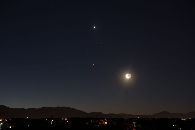 Dawn with a mountain foreground, the moon and three bright planets.