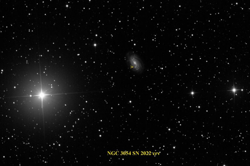 Bright star at left, fuzzy galaxy at center with bright spot by arrow.
