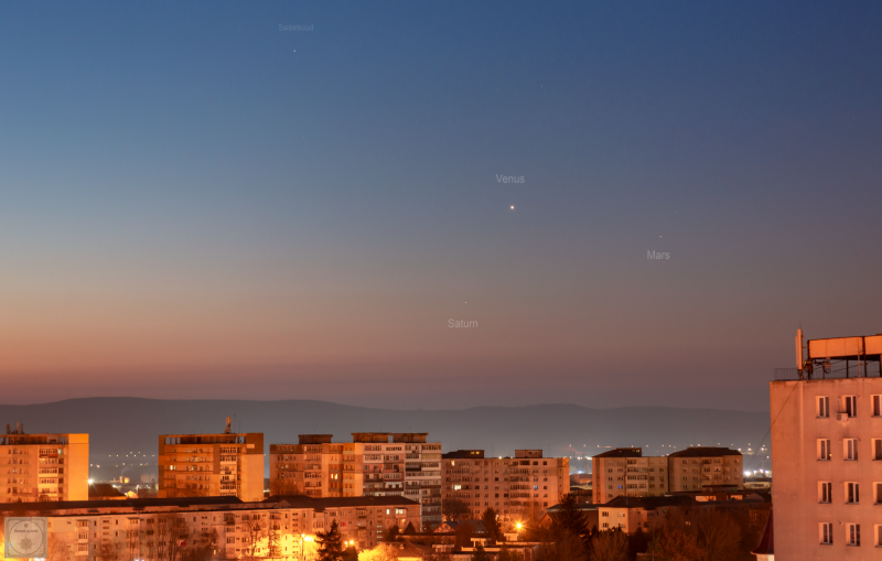 Morning planets: The dawn sky, with three bright planets and blocky apartment buildings in the foreground.
