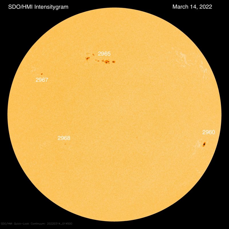 Sun news: Round yellow globe of sun, with sunspot groups labeled.