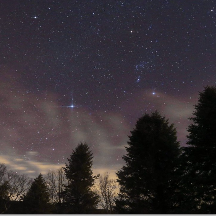 Sky with constellation Orion and a bright star, Sirius, to the lower left.