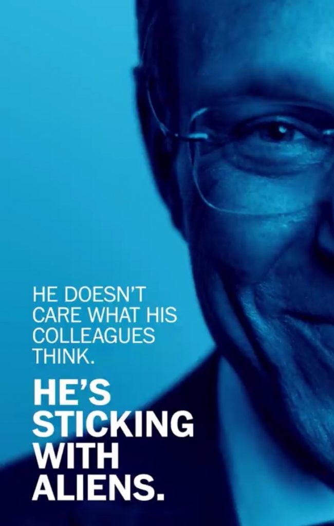 Blue-toned image of half a man's smiling face with glasses and text.