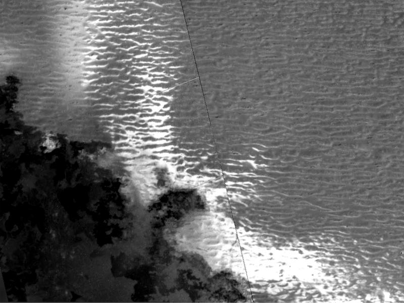 Io's enigmatic dunes: Wavy ridges on alternating dark and bright surfaces.